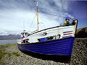 Icelandic tot playing in a beached boat in Djúpivogur.