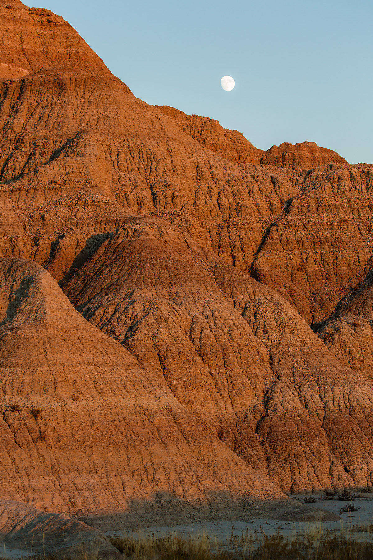 The last rays of the setting sun light the Badlands as the almost-full moon rises.  Click for next photo.