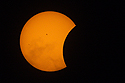 Start of the partial phase of the eclipse, orange mylar filter.  Some thin clouds in the lower half.